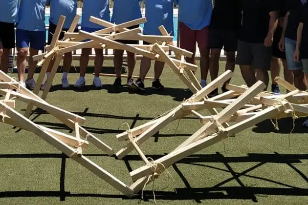 Equipo junto al puente de madera que ha construido