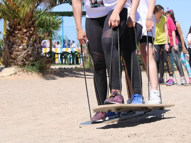 Equipo manteniendo el equilibrio sobre una tabla en la playa